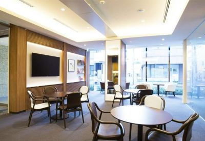 Spacious communal lounge area with a large television, modern seating, and bright natural light.