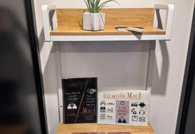 Compact wooden workstation with a floating shelf, small plant, and laptop.