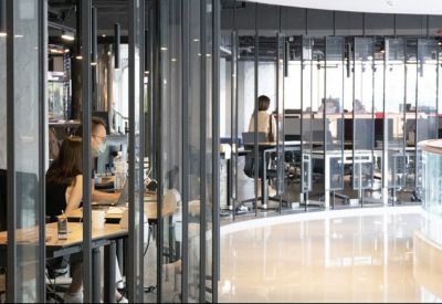 Curved glass wall partitions in a coworking space.