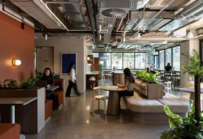 Vibrant communal lounge featuring velvet booths, indoor plants, and warm accent lighting.