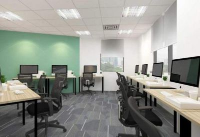 Spacious open-plan workspace with a green feature wall and rows of ergonomic desks.