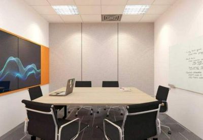 Bright conference room with a large screen, whiteboard, and seating for six.