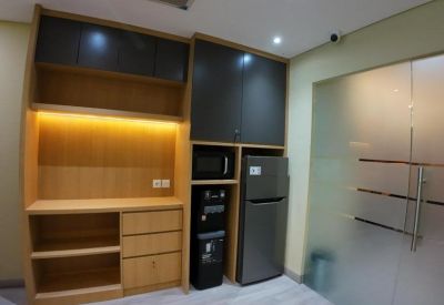 Compact kitchenette area with wooden cabinetry, microwave, and refrigerator.