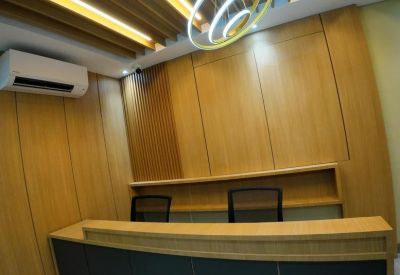 Reception desk area featuring wood paneling and a modern circular pendant light.