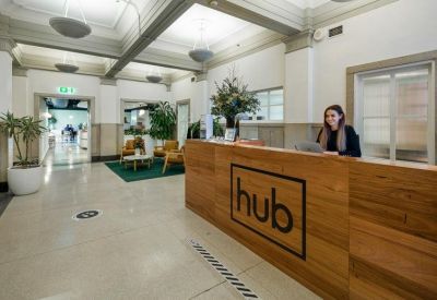 Stylish reception area with a timber front desk and logo signage.