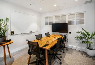 Professional meeting room with a wooden table, whiteboard, and television.