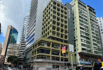Spacious open-plan coworking area with white desks and large windows.