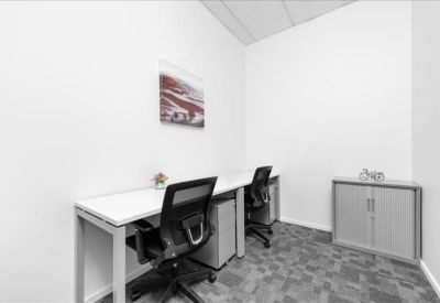 Private two-person office suite with white desks, ergonomic chairs, and a framed wall art piece.
