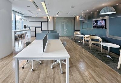 Breakout lounge featuring grey high-back privacy chairs and a wall-mounted TV.