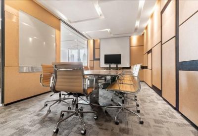 Sleek boardroom with tan leather chairs and warm wood paneling.