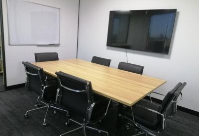 Professional meeting room featuring a large timber table and wall-mounted monitor.
