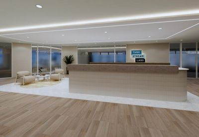 Bright reception area with a long timber desk and comfortable lounge seating.