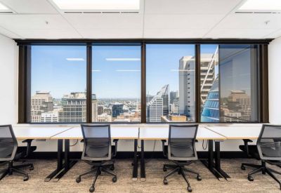 Four-person workstation area with large windows and city views.
