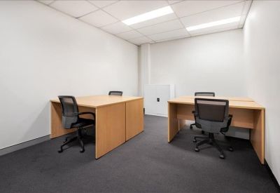 Private internal office suite with two light wood desks and black mesh chairs.