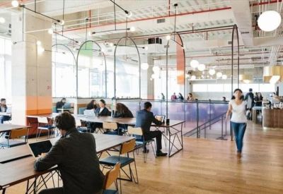 Open-plan office with individual workstations, wooden flooring, and arched glass partitions.