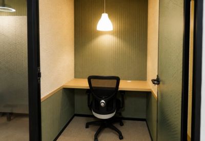 Private single-person focus pod with a warm pendant light and acoustic wall panels.