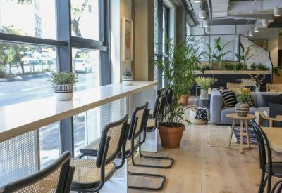 Bright window-side breakfast bar with tall stools and potted plants overlooking the street.