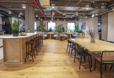Modern kitchen and dining area featuring a large wooden table and island bench with bar stools.