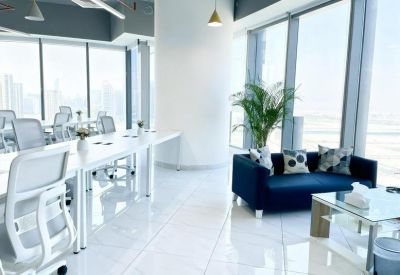 Open office layout with casual seating and large windows.