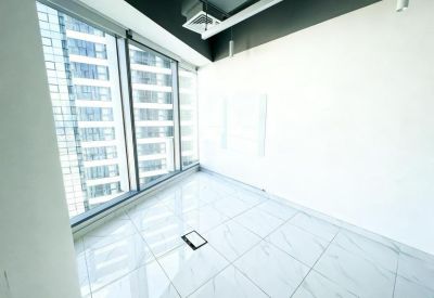 Vacant room with floor-to-ceiling windows and city views.