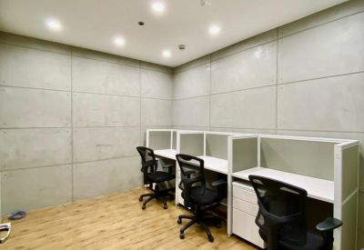 Private office suite with three workstations and industrial-style concrete walls.