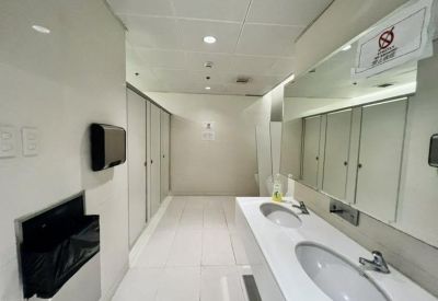 Modern restroom with white marble countertops and multiple stalls.