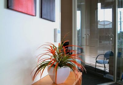Reception area featuring a wooden sideboard with a plant and abstract art.