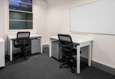 Private office suite with two white desks and a whiteboard.
