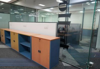 Storage area with wood-finish cabinets and blue shelving under a glass partition.