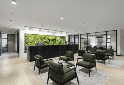 Spacious reception area with a black marble desk and green plant feature wall.