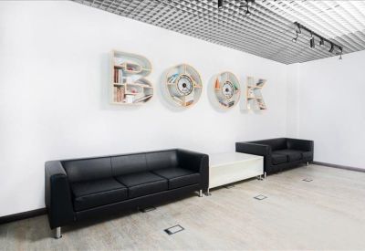 Lounge area with black leather sofas and large creative wall art spelling BOOK.