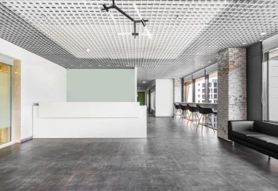 Modern reception lobby with a white minimalist desk and dark stone flooring.