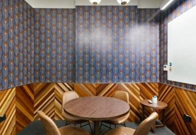 Small meeting room featuring patterned wallpaper and chevron wood paneling.