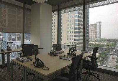 Private office with two desks and large windows overlooking city skyscrapers.