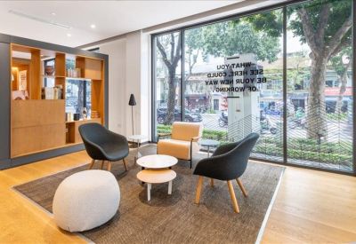Casual lounge area with colorful chairs and a large window overlooking trees.