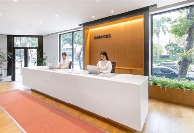 Modern white reception desk with staff and warm wood paneling.