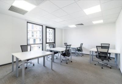 Bright private office suite with multiple white desks and ergonomic chairs.