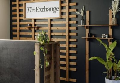 Modern reception desk with a timber lattice feature wall and branded signage.