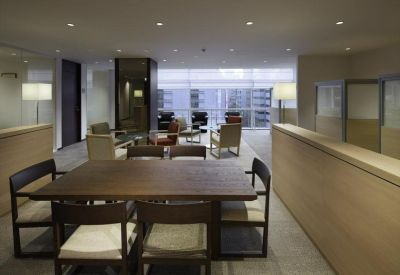 Open-plan meeting area with a large dark wood table and low partitions.