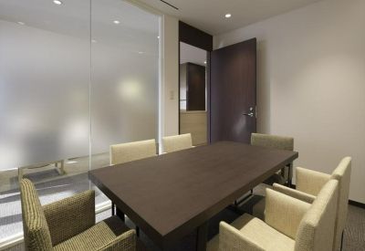 Private conference room with a large wooden table and frosted glass walls.