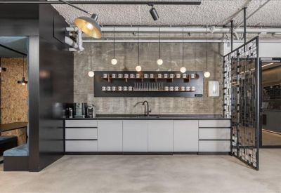 Industrial-style kitchen area with a sleek grey counter, modern faucet, and designer pendant lights.