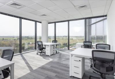 Bright corner office with floor-to-ceiling windows and multiple white desks.