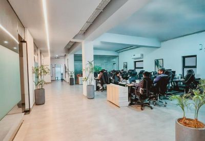 Modern open-plan office and workspace at 3, Block E, Lahore, Pakistan with people working and indoor greenery.