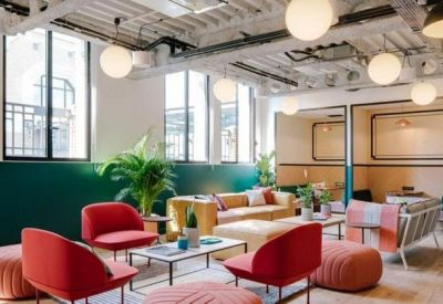 Spacious lounge with vibrant red chairs and green accent walls.
