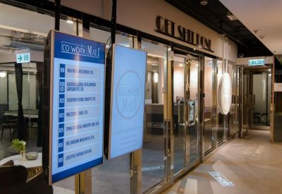The entrance to the workspace featuring a digital directory board and glass doors.