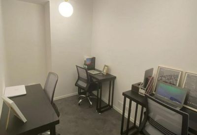 A private three-desk office suite with ergonomic chairs and modern pendant lighting.