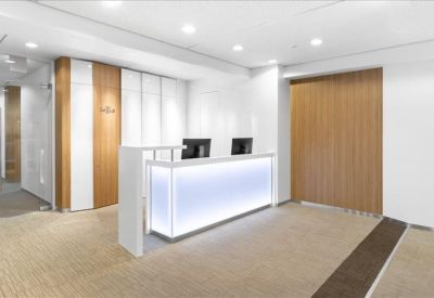 Modern reception area with a sleek, illuminated front desk and wood-paneled walls.