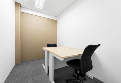 Compact private office featuring a wooden desk and black ergonomic chair.