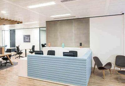 Modern reception area featuring a light blue textured desk and warm wooden flooring.