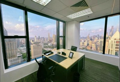 Bright corner office with two large windows offering panoramic views of the city skyline.